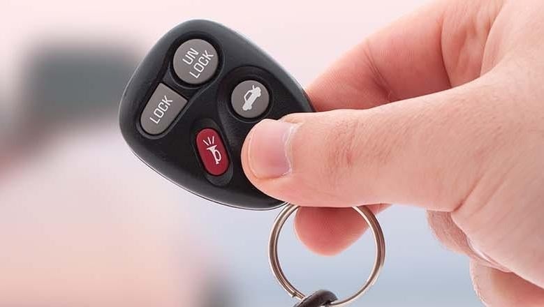 image of a person holding a car key fob